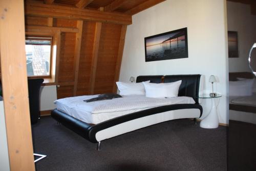 a bedroom with a large bed with a black frame at City-Hotel in Plauen