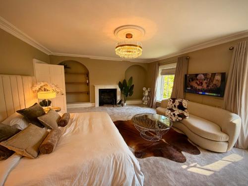 a bedroom with a bed and a couch and a fireplace at La Mancha Hall Stately Home in Halsall