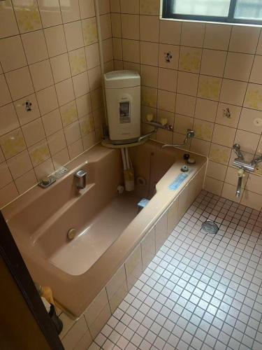 a bathroom with a bath tub with a water tank at 静佳民宿 in Osaka