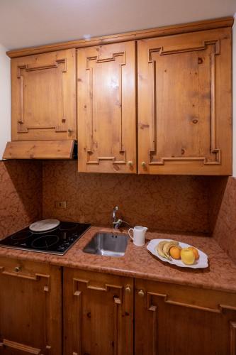 un bancone della cucina con un lavandino e un piatto di frutta di Hotel Posta R.T.A. a Madonna di Campiglio