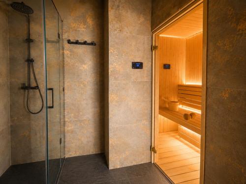 a bathroom with a shower and a walk in shower at Mergen Bike & Ski Resort- basen, sauna, jacuzzi in Niedzica Zamek