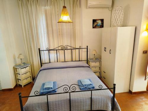 a bedroom with a bed with two night stands and a refrigerator at Sunrise Stagnone - Relax Sea Rooms in Marsala