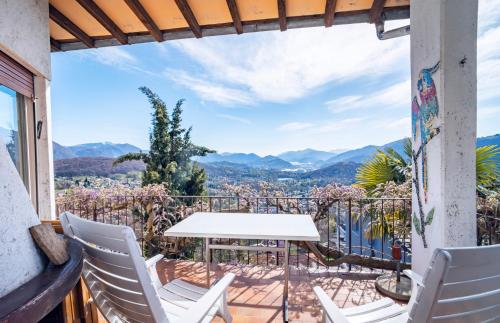 a balcony with a table and chairs and mountains at Lugano Hills View & Parking in Bigorio