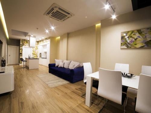 a living room with a blue couch and a table at Softly Residence in Bydgoszcz