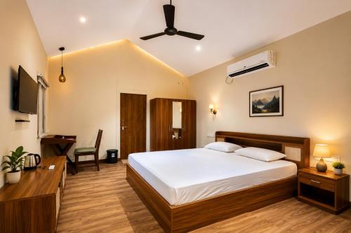 a bedroom with a large bed and a desk at Mango Shack Villa in Trimbak