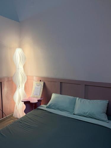 a bedroom with a bed with a lamp and a book at 75 Staytion in Bien Hoa