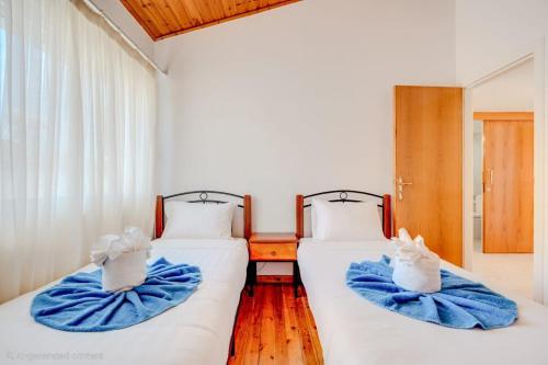 two beds in a room with blue towels on them at Salt & Sun Retreat in Perivolia