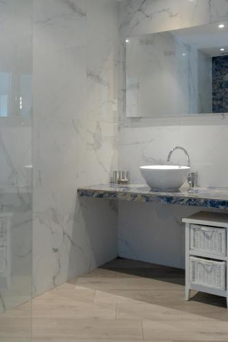 a white bathroom with a sink and a mirror at Casa Martini in Bonifacio