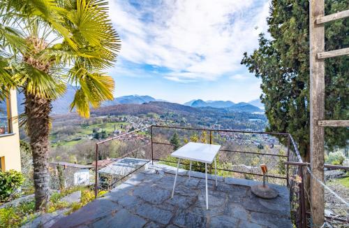 a white table on a balcony with a view of mountains at Lugano Hills View & Parking in Bigorio
