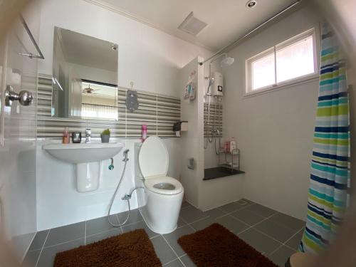 a bathroom with a toilet and a sink at J&Y Happy Home in Ban Rong