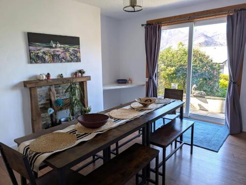a dining room with a wooden table with chairs at Callart View in Ballachulish