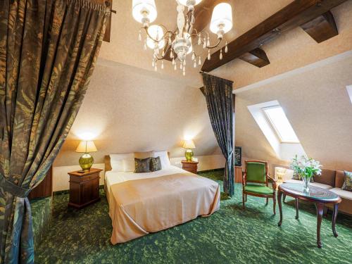 a hotel room with a bed and a chandelier at Platán Utca - Platán Tata in Tata