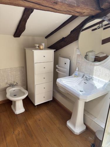a bathroom with a white sink and a toilet at Fontaine de Champagne in Champagne-et-Fontaine