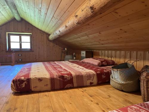 a bedroom with two beds in a log cabin at Baita Lodge Valfreda in Falcade