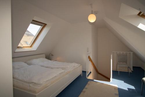 a bedroom with a bed in a attic with a window at Ferienwohnung Filter in Hörnum