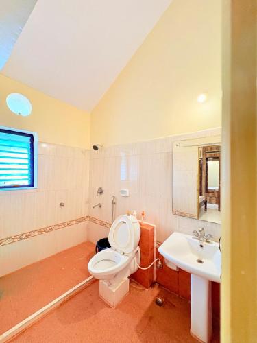a bathroom with a toilet and a sink at Serenity Villa in Rushikonda