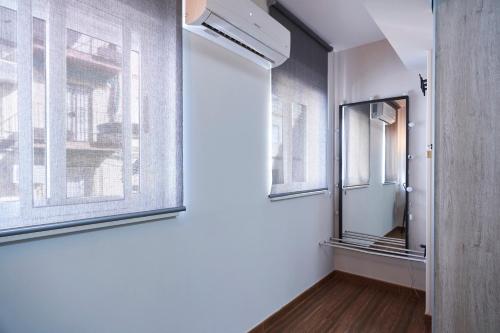 a hallway with two windows and a mirror at The Clock Tower Apartment in Jaén