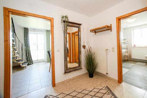 a hallway with a mirror and a staircase at Ferien- und Pferdehof Egelkraut "Feriendomizil am Meer" in Wangerland