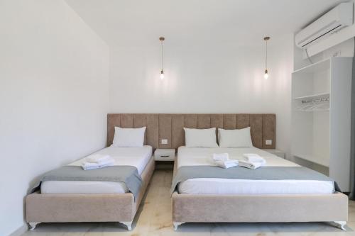 two beds in a room with white walls at Vila Ori in Ksamil