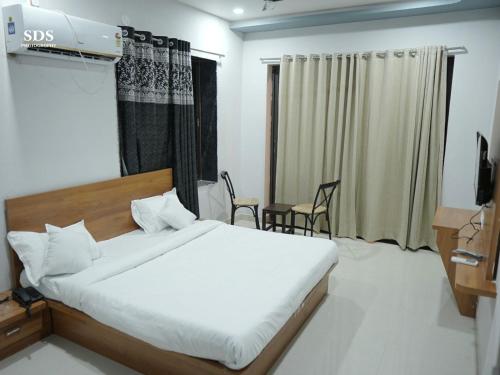 a bedroom with a bed and a table and chairs at Hotel Chandra Hari Palace in Sānchor