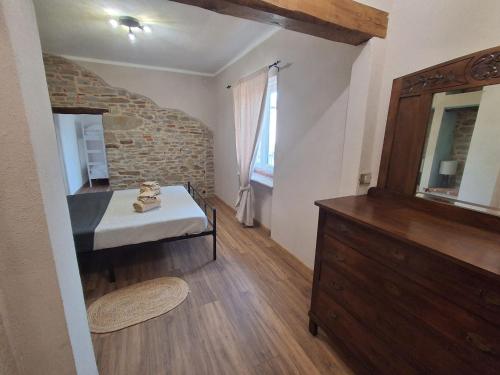 a bedroom with a bed and a dresser in a room at Bella vista 2 in Castellino Tanaro