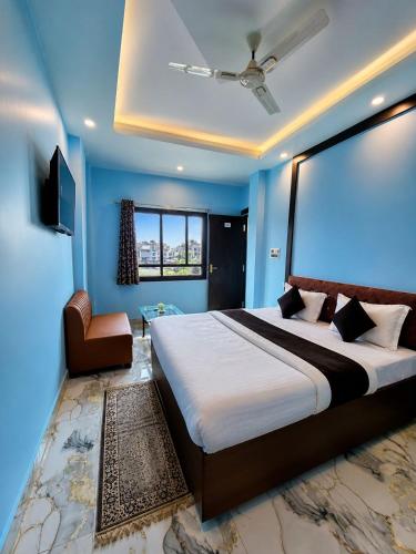 a bedroom with a large bed and a chair at Hotel 5G in Bhopal
