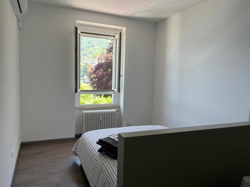 a white room with a bed and a window at Casa Luisa in Bellano