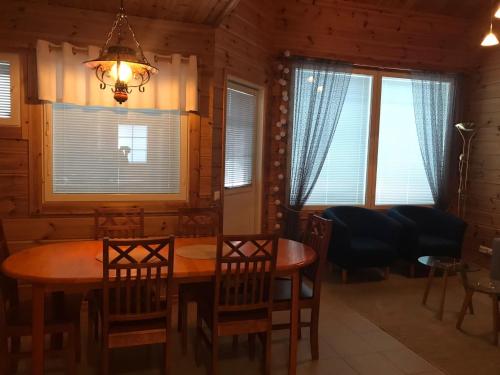 a dining room with a table and chairs and windows at Tenutahko in Tahkovuori