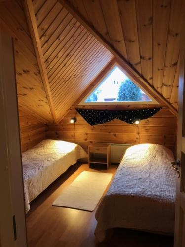 a attic room with two beds and a window at Tenutahko in Tahkovuori