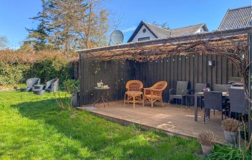a wooden deck with chairs and tables in a backyard at 2 Bedroom Nice Home In Hundested in Hundested
