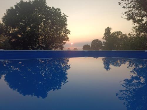 a pool of water with a sunset in the background at La cabane in Montipouret
