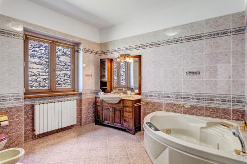 a bathroom with a tub and a sink at Villa Porlezza Lake view in Cima