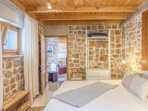 a bedroom with a bed and a stone wall at Dolce Terra in Stari Grad