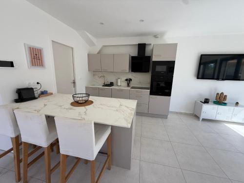 a kitchen with a table and some white cabinets at Villa ROC in Bandol
