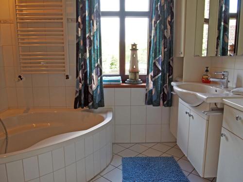 a bathroom with a large tub and a sink at Ferienhaus am Badesee 4 in Aurich