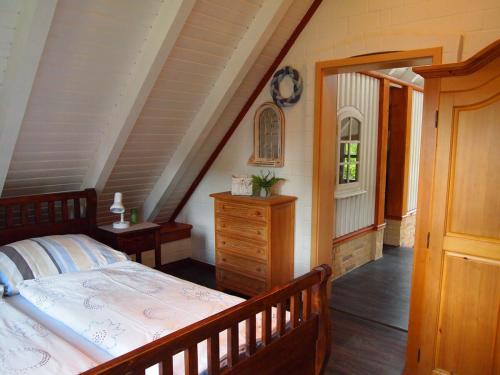 a bedroom with a bed and a dresser in a attic at Ferienhaus am Badesee 4 in Aurich