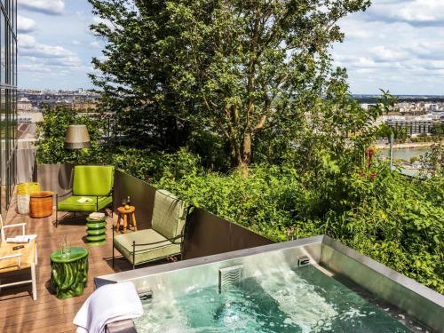 a hot tub on the balcony of a building at Too Hotel & Spa Paris - MGallery Collection in Paris