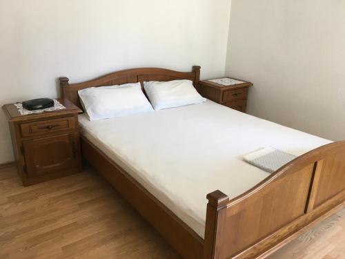 a bedroom with a large bed with two night stands at Apartman Nadia in Karlobag