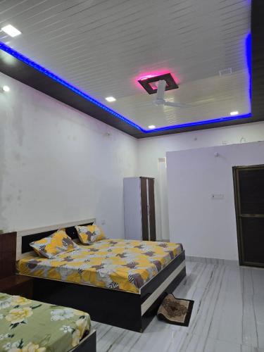 a bedroom with two beds and a purple light on the ceiling at Pandeyji stay in Ayodhya