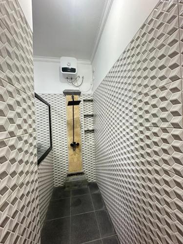 a small hallway with a wall of white tiles at Hideaway in Amed