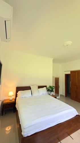 a bedroom with a large bed with white sheets at Hideaway in Amed