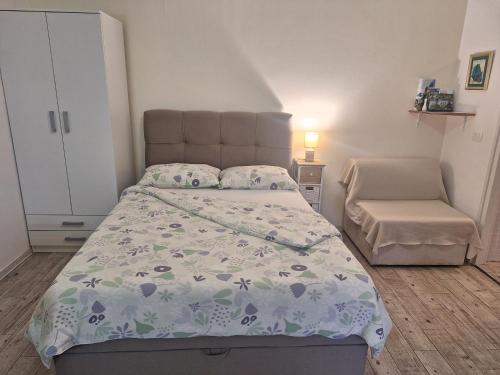a small bedroom with a bed and a chair at Studio Laura in Ičići