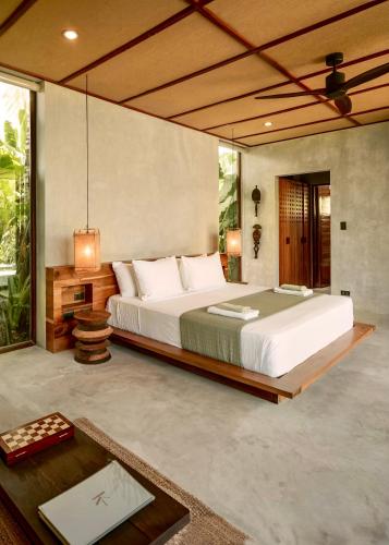a bedroom with a large bed and a table at Kamaya - Private Villa with Pool in General Luna