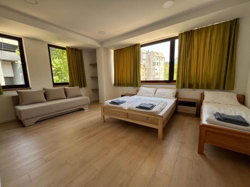 a bedroom with two beds and a couch and windows at Green River in Konjic