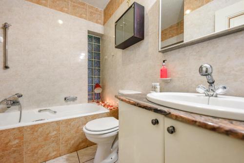 a bathroom with a sink and a toilet and a tub at Villa Simonne in Johannesburg