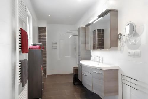 a white bathroom with a sink and a shower at Villa Reny in Meltina