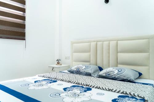 a bed with blue and white sheets and pillows at JY Apartments in Negombo