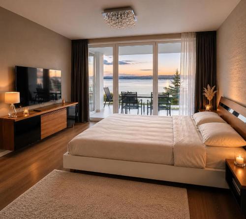 a bedroom with a large bed and a television and a table at Marcelo Deluxe Apartment in Tihany