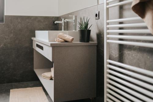 a bathroom with a sink and a counter with towels at Montoni Chalets in Prato allo Stelvio