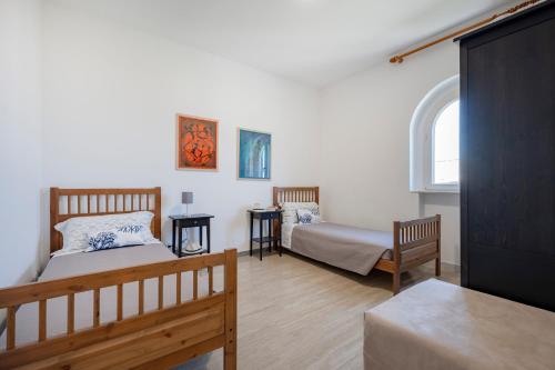 a bedroom with two beds and a window at Casa del Riccio fronte mare in Mola di Bari